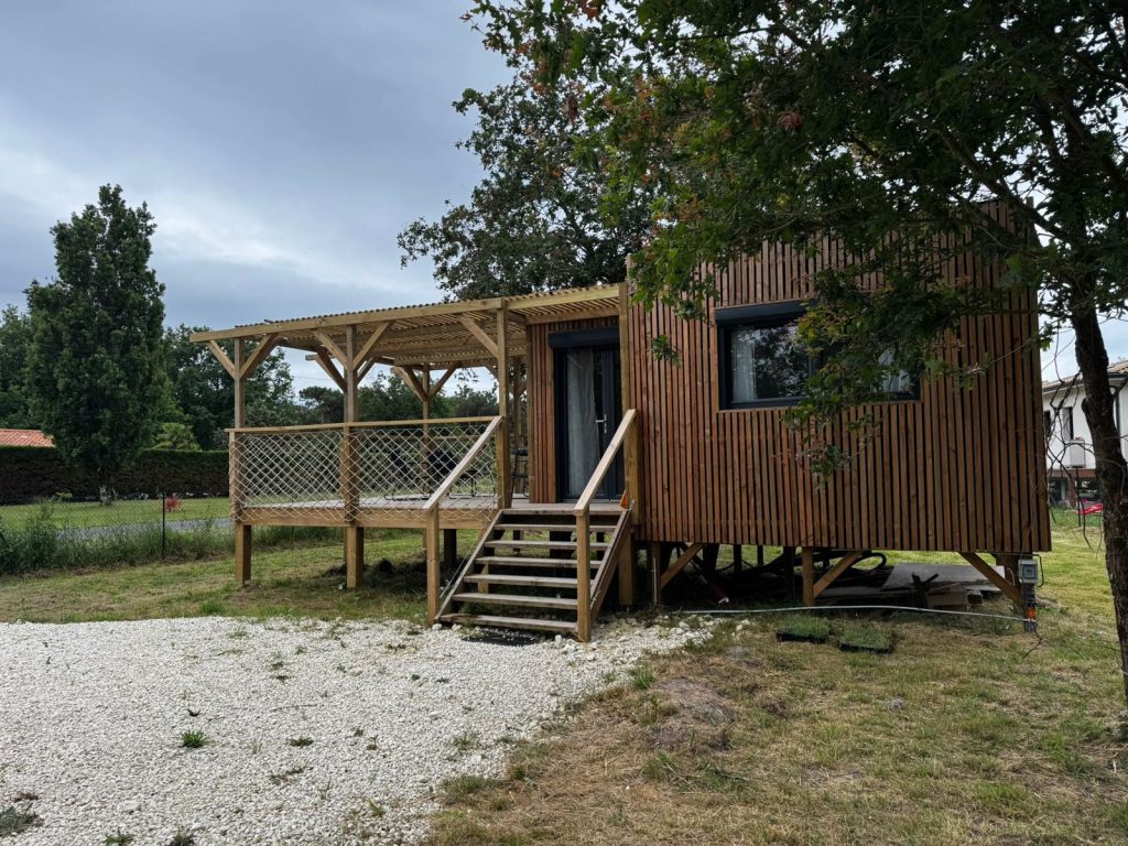 La tiny et son escalier de bois, entourés de chênes