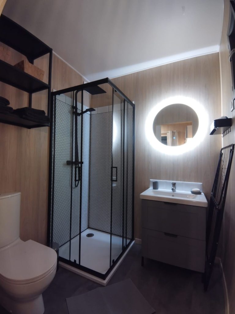 Salle d’eau avec douche et miroir lumineux